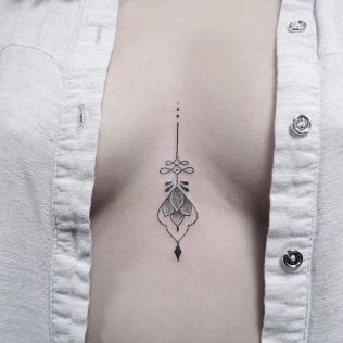 Mały tatuaż między piersiami