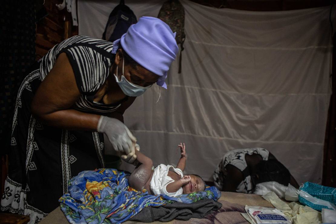 Zimbabwe - położna bada ciało noworodka po narodzinach