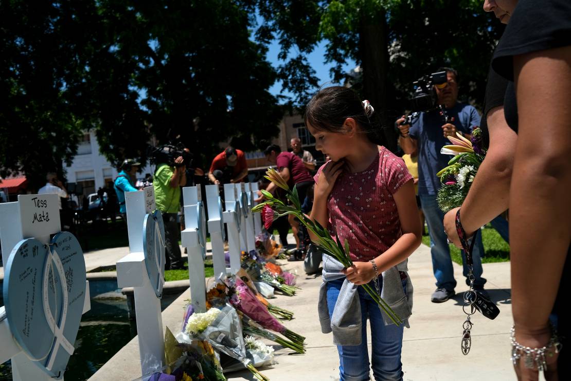 Makaylah Ovalle, która przeżyła strzelaninę, składa kwiaty pod symbolicznym pomnikiem zabitych uczniów i nauczycieli szkoły podstawowej w Uvalde.